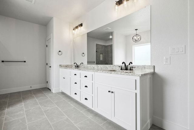 bathroom with vanity, an inviting chandelier, a shower with shower door, and tile patterned floors