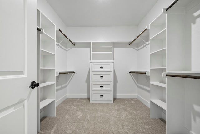 walk in closet featuring light colored carpet