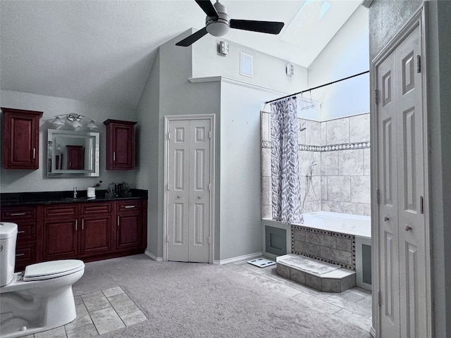 full bathroom featuring ceiling fan, toilet, a skylight, shower / bath combo with shower curtain, and vanity