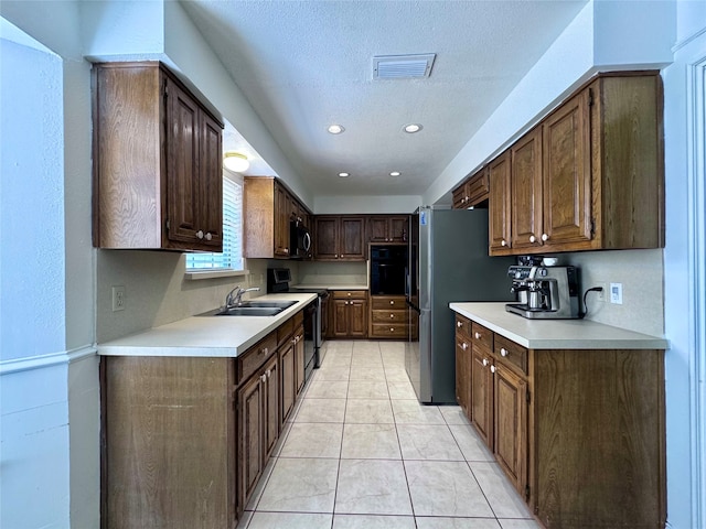 kitchen with oven, dark brown cabinetry, sink, electric stove, and light tile patterned flooring