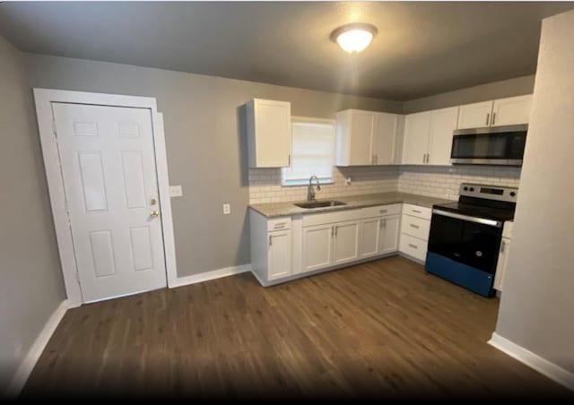 kitchen with decorative backsplash, dark hardwood / wood-style flooring, white cabinetry, appliances with stainless steel finishes, and sink