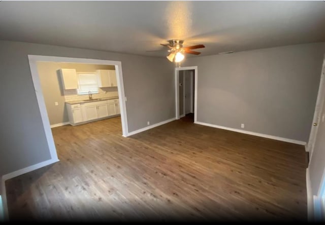 unfurnished bedroom featuring sink, ceiling fan, and wood-type flooring