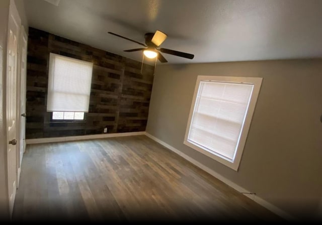 empty room with hardwood / wood-style flooring and ceiling fan