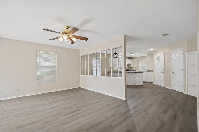 unfurnished living room with ceiling fan, plenty of natural light, and hardwood / wood-style floors