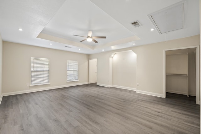 empty room featuring ceiling fan, a raised ceiling, and hardwood / wood-style floors