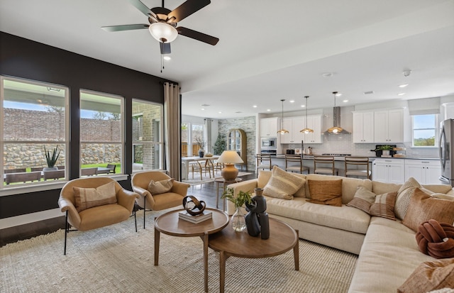 living room featuring a wealth of natural light, light hardwood / wood-style floors, and ceiling fan