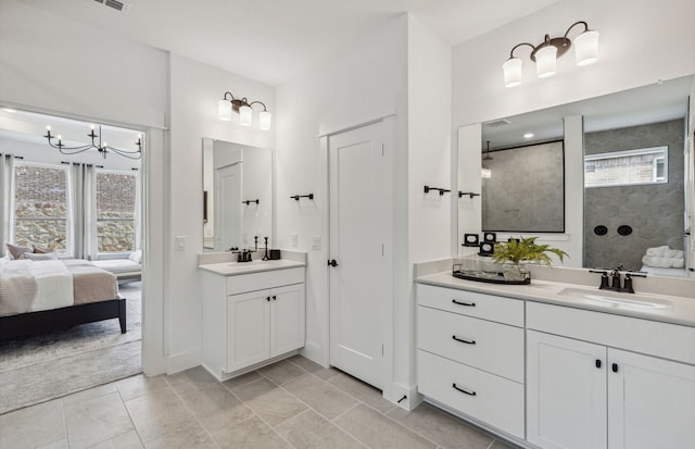 bathroom with tile patterned flooring, vanity, a healthy amount of sunlight, and a tile shower