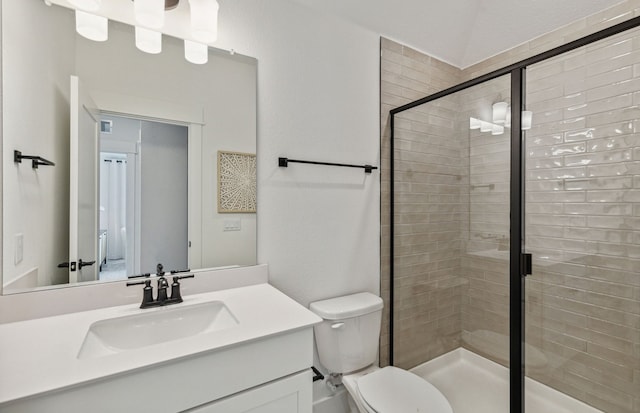 bathroom with a shower with shower door, vanity, and toilet