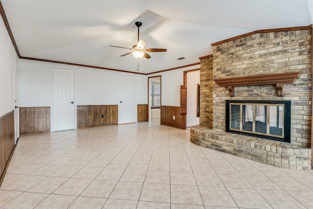 unfurnished living room with a textured ceiling, ceiling fan, light tile patterned flooring, and a brick fireplace