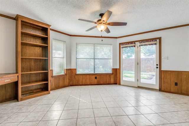 tiled empty room featuring ceiling fan, crown molding, and a textured ceiling