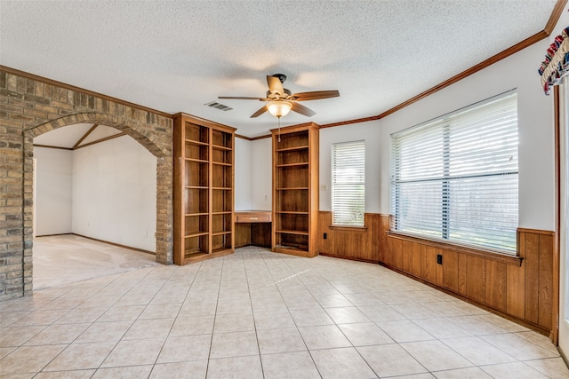 empty room featuring light tile patterned floors, brick wall, and ceiling fan