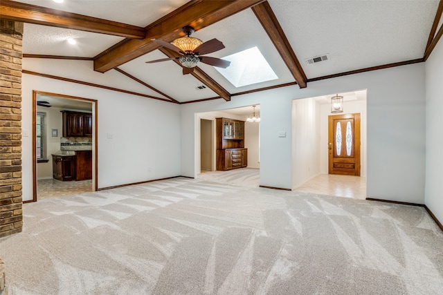 spare room featuring ceiling fan, brick wall, light carpet, vaulted ceiling with skylight, and a textured ceiling