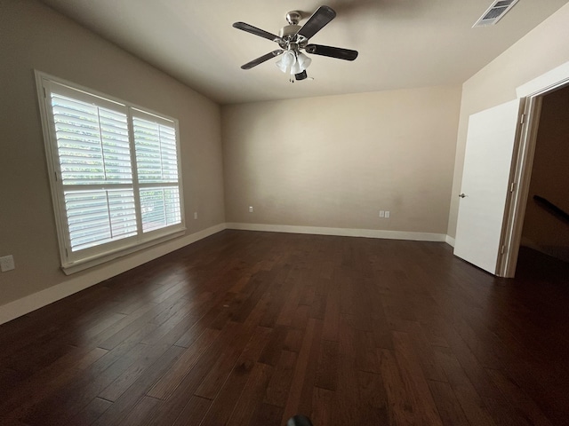 empty room with ceiling fan and dark hardwood / wood-style flooring