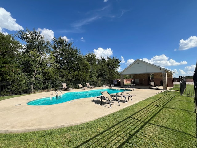 view of swimming pool featuring a lawn and a patio