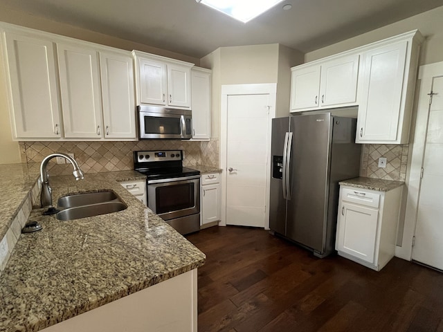 kitchen with white cabinetry, sink, stainless steel appliances, and decorative backsplash