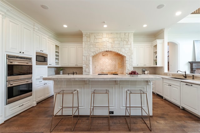 kitchen with a kitchen breakfast bar, stainless steel appliances, dark wood-type flooring, and decorative backsplash