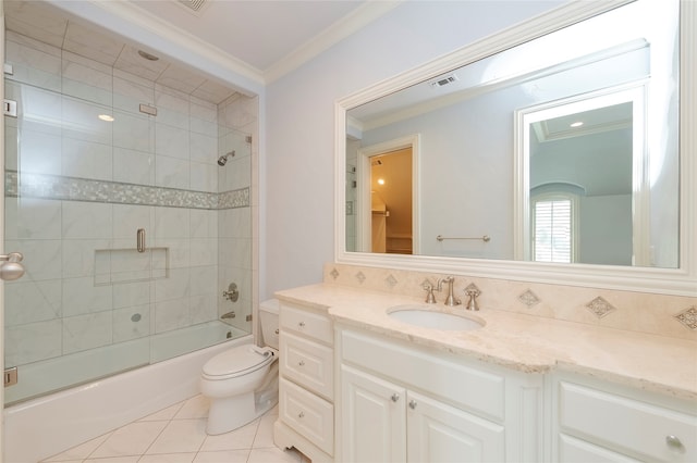 full bathroom featuring tiled shower / bath, tile patterned flooring, vanity, crown molding, and toilet