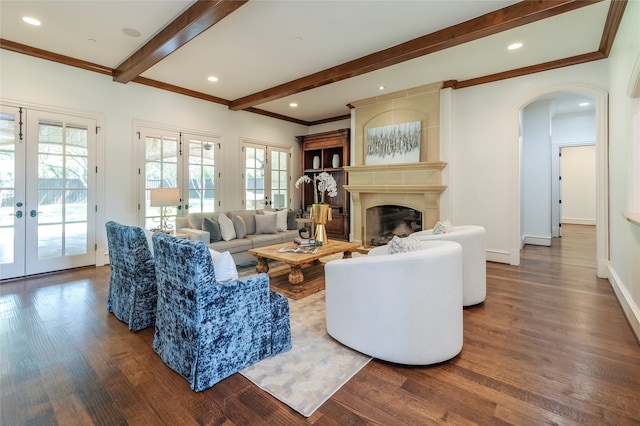 living room featuring french doors, dark hardwood / wood-style floors, a large fireplace, and ornamental molding