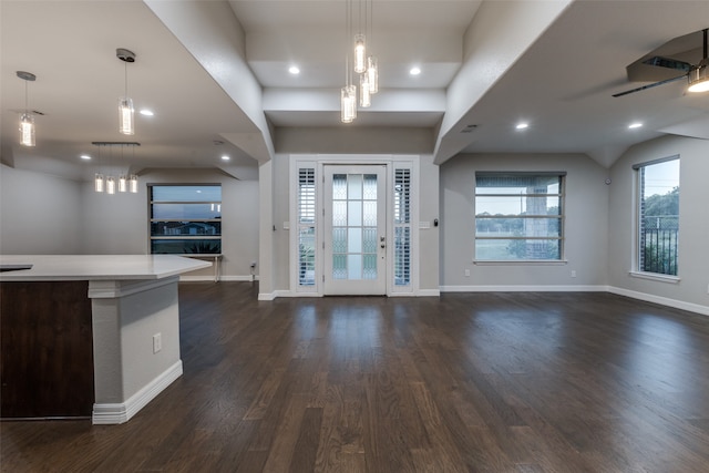 interior space featuring ceiling fan with notable chandelier and dark hardwood / wood-style flooring