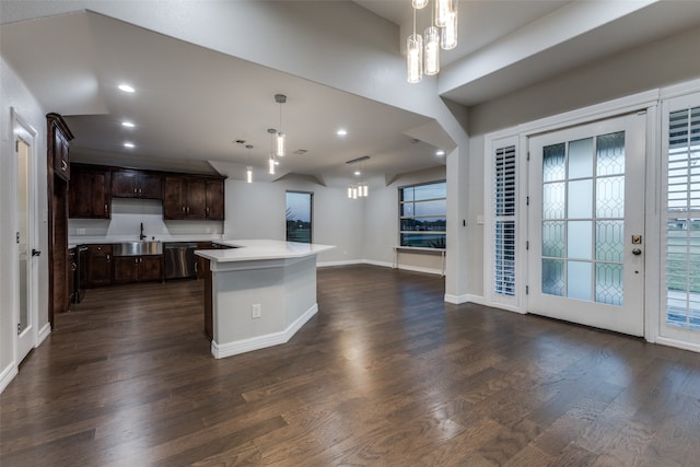 kitchen featuring a kitchen island, dark wood-type flooring, dark brown cabinetry, and hanging light fixtures