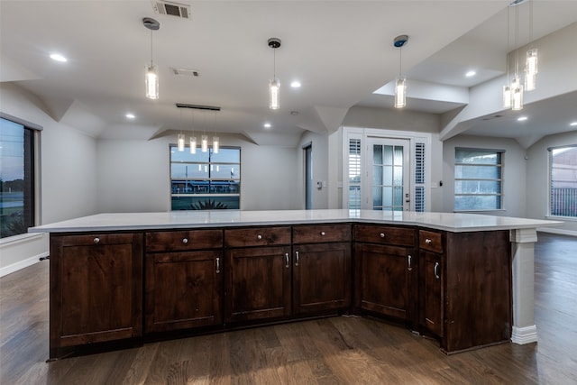 kitchen featuring a center island, dark brown cabinetry, dark hardwood / wood-style flooring, and decorative light fixtures