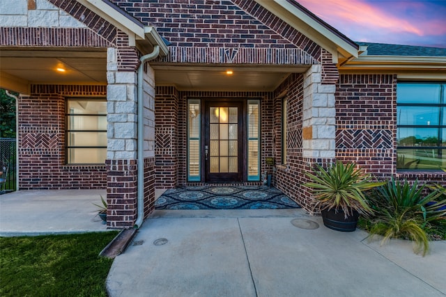 exterior entry at dusk with a patio