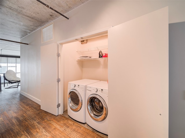 washroom with hardwood / wood-style flooring and washing machine and clothes dryer