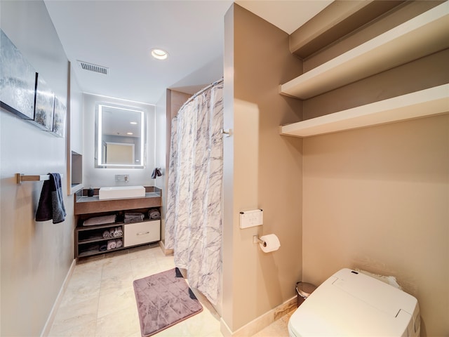 bathroom with tile patterned floors, vanity, and toilet