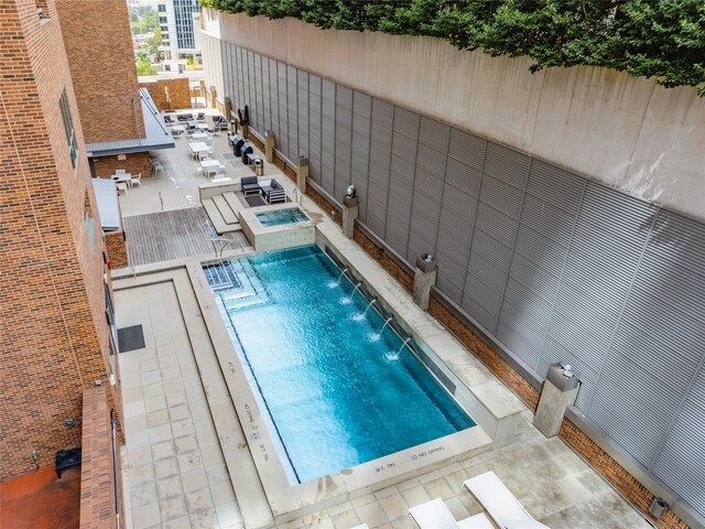 view of swimming pool featuring pool water feature and a patio area