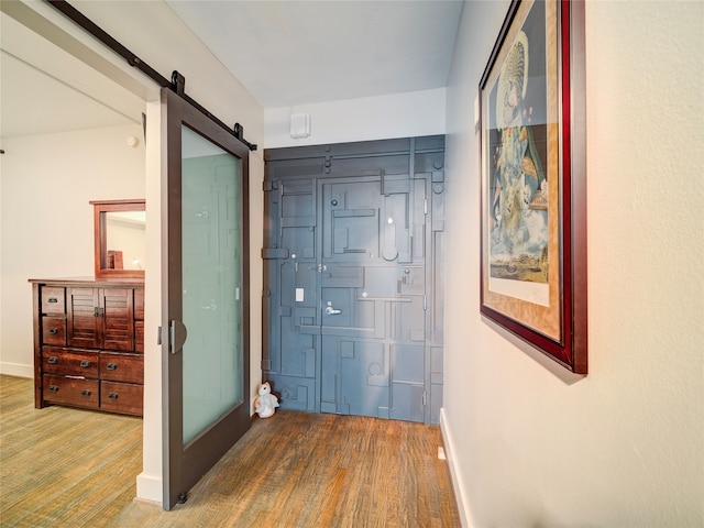 corridor with hardwood / wood-style floors and a barn door