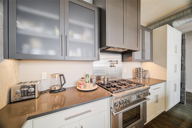 kitchen featuring high end range, decorative backsplash, dark hardwood / wood-style flooring, and gray cabinets