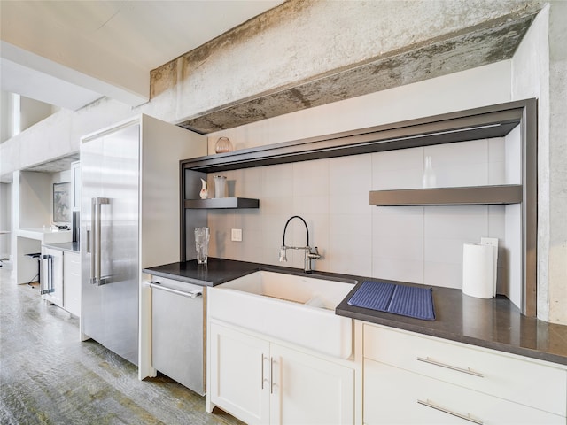 kitchen featuring sink, white cabinetry, white dishwasher, and tile walls