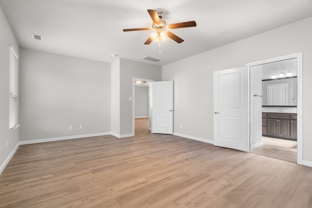 unfurnished bedroom with ceiling fan, light wood-type flooring, and ensuite bath