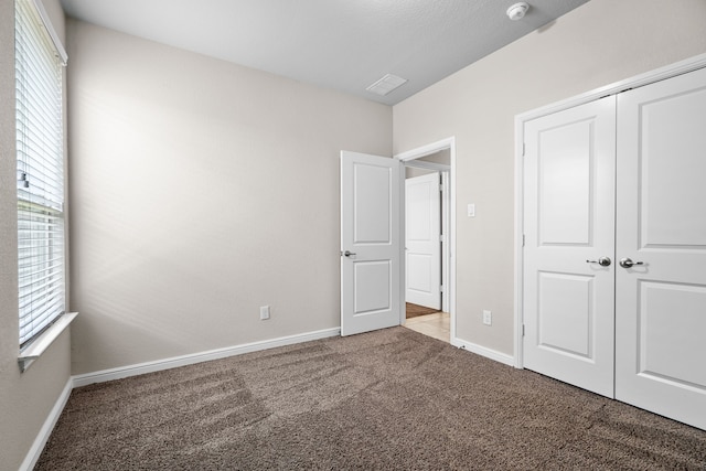 unfurnished bedroom featuring carpet flooring and a closet