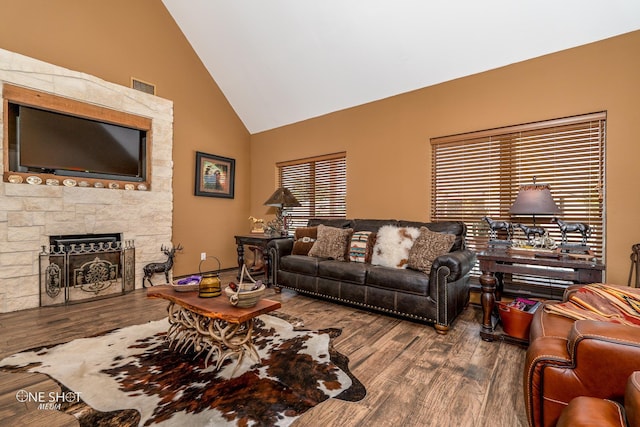 living room with a fireplace, high vaulted ceiling, and hardwood / wood-style floors