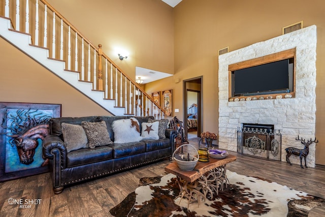 living room featuring a stone fireplace and wood-type flooring