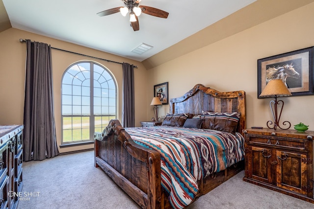 bedroom featuring ceiling fan, vaulted ceiling, and light carpet