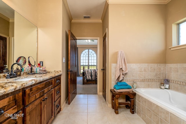 bathroom featuring tiled tub, crown molding, a wealth of natural light, and tile patterned floors