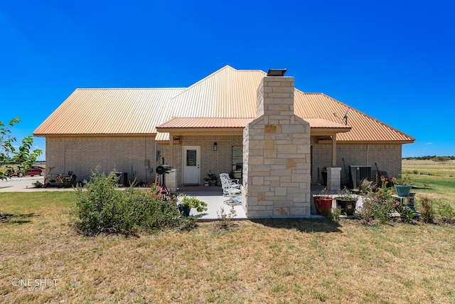 back of property with a patio, a yard, and central air condition unit