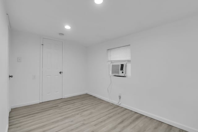 empty room with cooling unit and light hardwood / wood-style floors