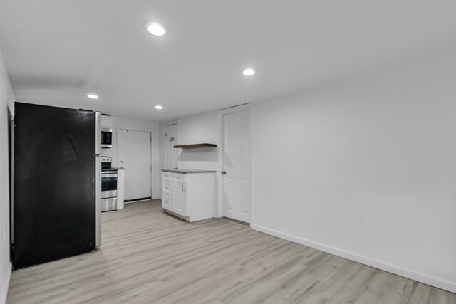 kitchen with white cabinets, appliances with stainless steel finishes, and light hardwood / wood-style flooring