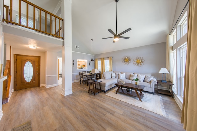 living room with ceiling fan, high vaulted ceiling, and light wood-type flooring