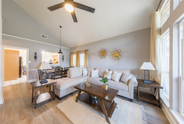 living room featuring ceiling fan, light wood-type flooring, and high vaulted ceiling