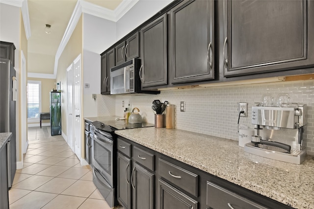 kitchen featuring backsplash, light stone counters, crown molding, and electric stove