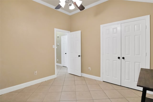 unfurnished bedroom with ceiling fan, light tile patterned floors, crown molding, and a closet