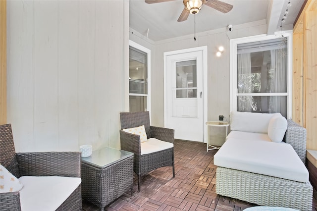 sunroom featuring ceiling fan