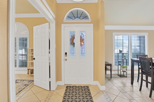 foyer entrance featuring light tile patterned floors and ornamental molding