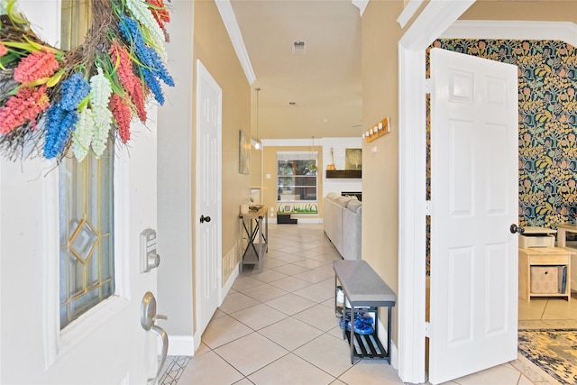 hall with light tile patterned floors and crown molding