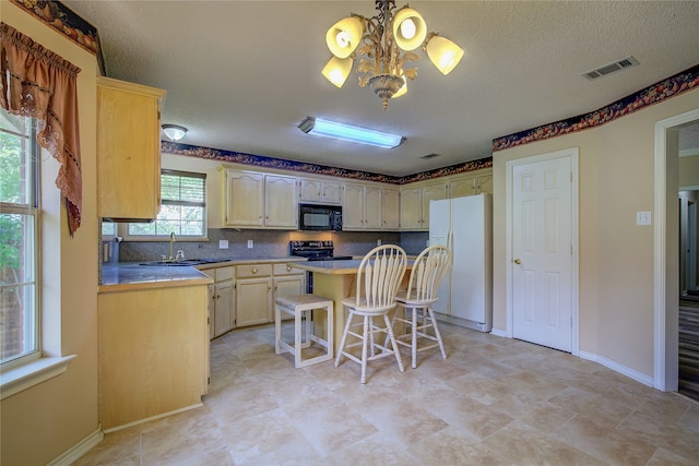 kitchen featuring a center island, a breakfast bar, light tile patterned flooring, and black appliances