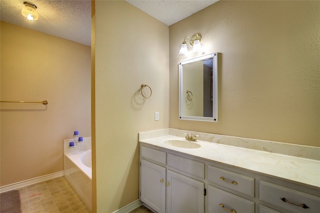 bathroom featuring tile patterned flooring, a tub, a textured ceiling, and vanity